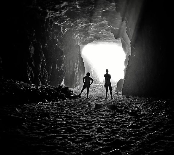 Dos personas observando la luz al final de una cueva